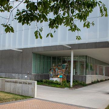 Exterior of the Fine Arts and Design Studios with a sculpture by the front door